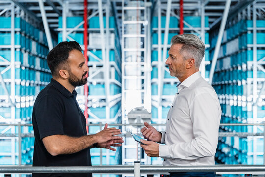 Businessman having discussion with manager at warehouse