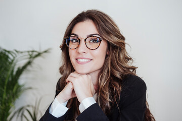 Businesswoman with hand on chin wearing eyeglasses at office