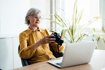Businesswoman with eyeglasses checking camera in office