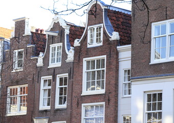 Fototapeta na wymiar Traditional Brown Brick House Facades with Bell Gables at the Begijnhof Courtyard in Amsterdam, Holland