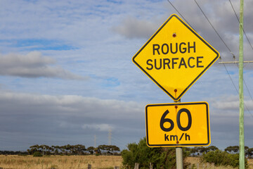rough surface and speed limit sign on the road against sky