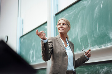 Businesswoman giving presentation by chalkboard at convention center