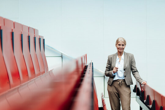Smiling businesswoman at auditorium seats row