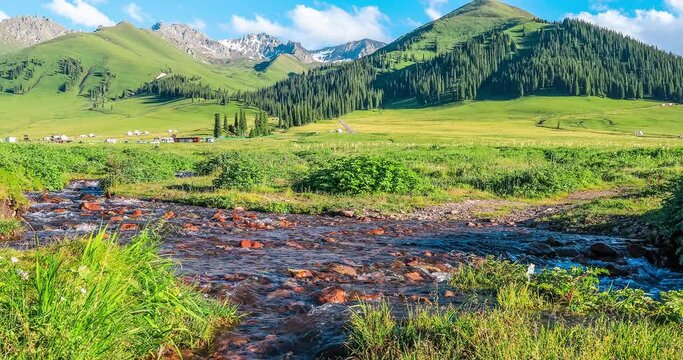 Streams and green mountains under the blue sky. Green grassland landscape in Xinjiang, China.