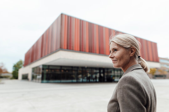 Smiling blond businesswoman in city