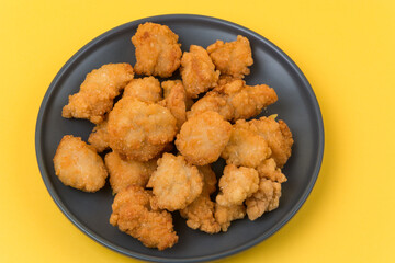 A plate of fried chicken with yellow background