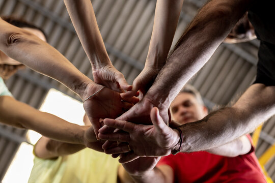 Athletes stacking hands together in gym