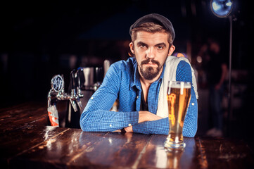 Confident tapster intensely finishes his creation in cocktail bars