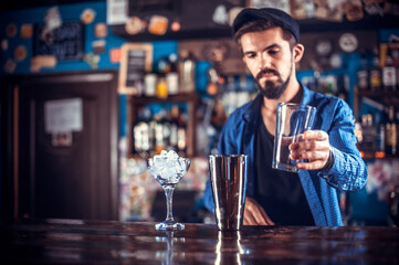 Bartender creates a cocktail in the bar