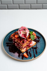 Soft waffles with berries and ice cream on vintage turquoise dash, white background menu photography
