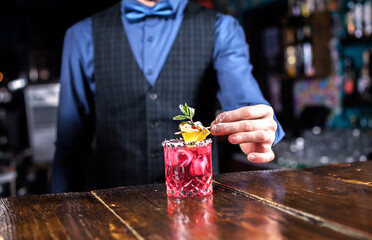 Barman concocts a cocktail at the bar