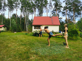 MICHURINSKOE .RUSSIA. A man, a boy and a girl play a game with metal balls on the lawn of a country...