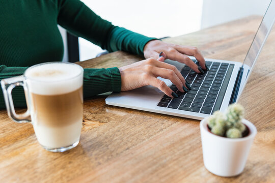 Freelancer using laptop at cafe table - Powered by Adobe