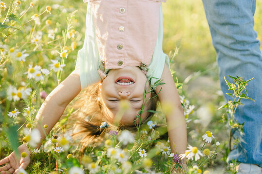 Carefree daughter playing with father by flowers