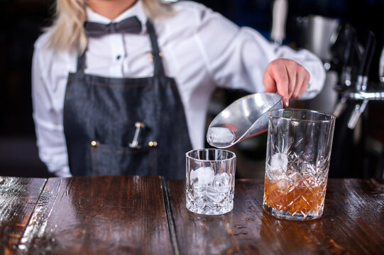 Girl barman makes a cocktail in the beerhouse