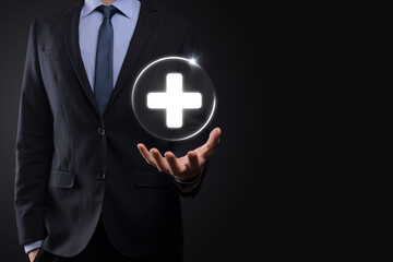 Businessman hold virtual plus medical network connection icons. Covid-19 pandemic develop people awareness and spread attention on their healthcare.