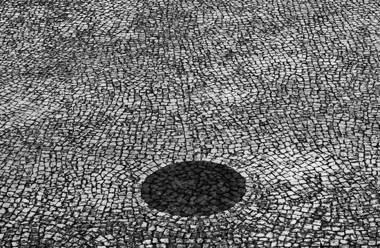 Black circle on cobblestone street