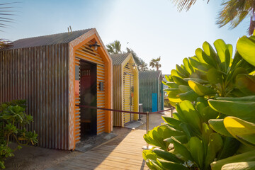 Fototapeta premium Bright colorful wooden houses on beach. Summer vacation at multicolored beach sheds huts. High quality photo