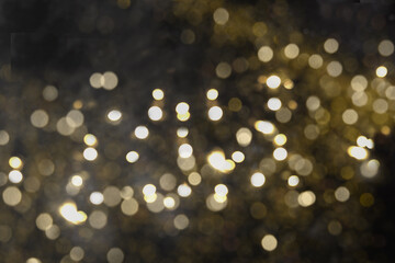 Fototapeta na wymiar Christmas beautiful gold shine sparkles on black background. Xmas festive abstract pattern.