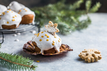 Christmas cupcakes. Xmas dessert with chocolate drops and marshmallow. Wooden background with Christmas decor and fir tree branches.