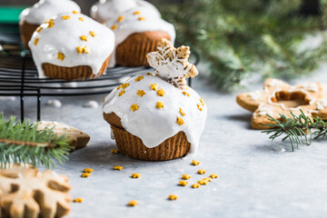 Christmas cupcakes. Xmas dessert with chocolate drops and marshmallow. Wooden background with Christmas decor and fir tree branches.