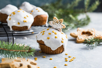 Christmas cupcakes. Xmas dessert with chocolate drops and marshmallow. Wooden background with Christmas decor and fir tree branches.