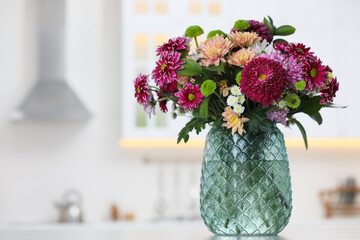 Bouquet of beautiful chrysanthemum flowers on table in kitchen, space for text