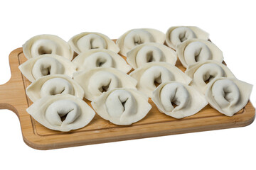 The process of making home-made dumplings. Raw homemade dumplings on a wooden board. Molding dumplings.