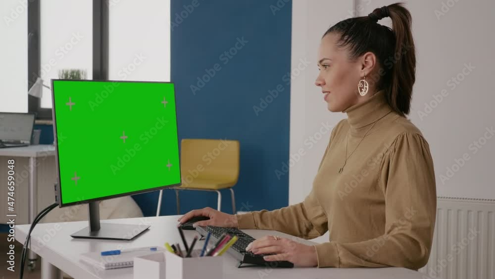 Poster person looking at green screen on computer display in office, working with isolated mock up template