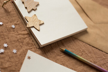 Notepad with blank white sheets on a brown background. Write a letter. Winter atmosphere. top view