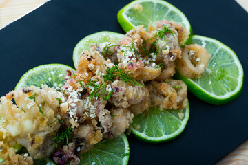 Fried calamari and sepia in batter of tempura flour and sesame on cushion of pickled limes..