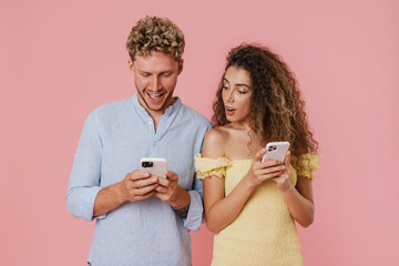 Young couple expressing surprise and frowning while using cellphones