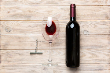Flat lay composition with corkscrew, bottle of wine and elegant glass on colored table. Flat lay,...