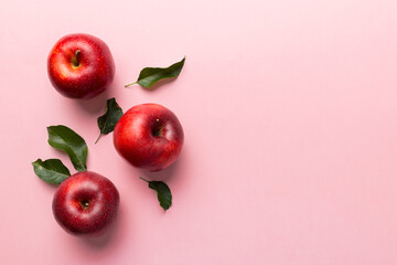 Many red apples on colored background, top view. Autumn pattern with fresh apple above view with...