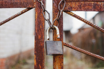 metal lock on a chain on a rusty gate