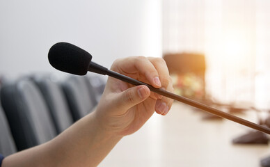Hold a conference microphone to speak on the conference table.