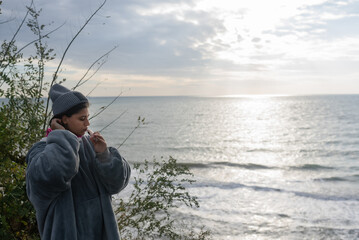 Obraz premium Woman brushing her teeth against the background of the sea sunrise