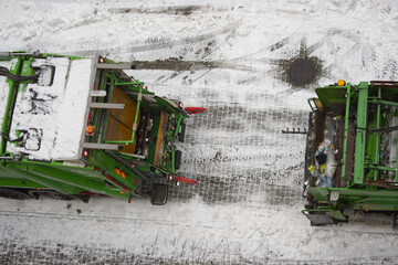 Two Garbage Truck Meet in the winter. Photo From Above And Covering Trucks Backs.