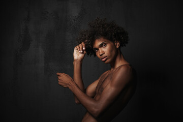 Shirtless black man with piercing posing and looking at camera