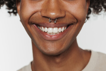 Fototapeta premium Young black man with piercing posing and smiling at camera