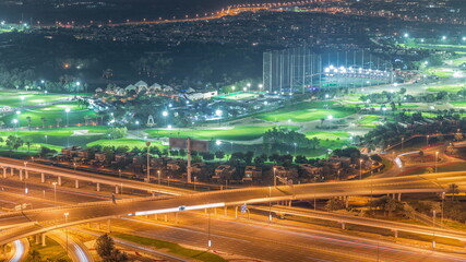 Fototapeta na wymiar Aerial view to Golf course with green lawn and lakes, villa houses behind it night timelapse.