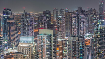 Dubai marina and JLT skyscrapers along Sheikh Zayed Road aerial night timelapse.