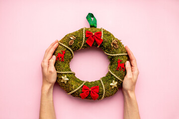 Festive Christmas wreath in hands. New year decoration background