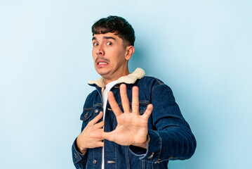 Young mixed race man isolated on blue background being shocked due to an imminent danger