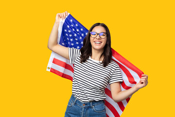 young cheerful multi ethnicity female holding american flag against yellow background
