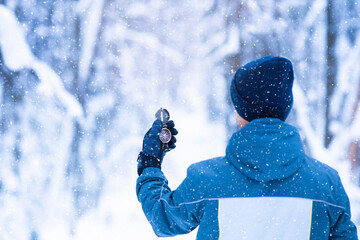 Navigate compass in man's hand on winter forest background for searching for right direction © Anita