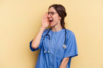 Young nurse caucasian woman isolated on yellow background shouting and holding palm near opened mouth.