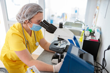 Skillful veterinarian uses microscope in animal hospital