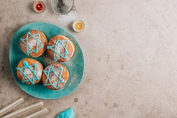Fototapeta na wymiar Traditional donuts for Jewish Holiday Hanukkah with Star of David on blue plate.