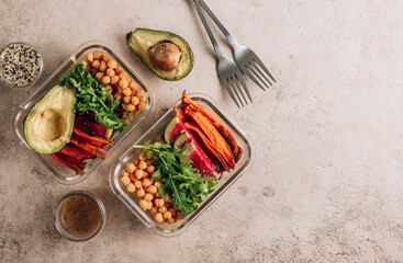 Vegan healthy meal prep containers. Chickpeas, sweet potatoes, arugula, radish and avocado for lunch